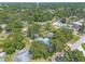 Aerial view of property surrounded by lush greenery, other neighborhood homes, and a water tower in the distance at 1927 Orange Tree Dr, Edgewater, FL 32141