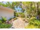 Serene backyard with brick pathway, mature trees, and lush landscaping for outdoor enjoyment at 1927 Orange Tree Dr, Edgewater, FL 32141