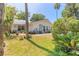 Spacious backyard with manicured lawn, brick pathway, and lush tropical landscaping at 1927 Orange Tree Dr, Edgewater, FL 32141