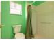 Bright bathroom featuring a toilet and shower with white tiling and curtain at 1927 Orange Tree Dr, Edgewater, FL 32141