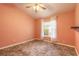 Cozy bedroom with decorative flooring, ceiling fan, and a window with sheer curtains at 1927 Orange Tree Dr, Edgewater, FL 32141
