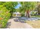 Long driveway leading up to a quaint home with mature landscaping and a metal roof at 1927 Orange Tree Dr, Edgewater, FL 32141