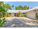 Home with a metal roof, blue trim, white siding, and a spacious driveway at 1927 Orange Tree Dr, Edgewater, FL 32141