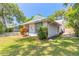 Charming home featuring a metal roof, manicured lawn, and vibrant blue trim around the windows at 1927 Orange Tree Dr, Edgewater, FL 32141