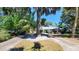 This single-story home features a metal roof, a circular driveway, and a front yard with mature trees at 1927 Orange Tree Dr, Edgewater, FL 32141