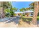 A charming home with long driveway, metal roof, mature trees and lush green lawn at 1927 Orange Tree Dr, Edgewater, FL 32141