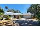 Well-maintained home with a metal roof, two-car garage, and lush landscaping enhancing its curb appeal at 1927 Orange Tree Dr, Edgewater, FL 32141