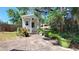 Charming outbuilding with a welcoming porch, nestled amidst mature landscaping and a stone pathway at 1927 Orange Tree Dr, Edgewater, FL 32141