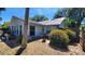 Home's rear view featuring large windows, established shrubbery, and partial view of a fenced yard at 1927 Orange Tree Dr, Edgewater, FL 32141