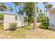 Outdoor storage shed features wood siding, a covered porch, and is surrounded by mature landscaping at 1927 Orange Tree Dr, Edgewater, FL 32141