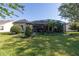 Expansive backyard with lush lawn, mature trees, and a screened-in lanai at 202 Westcott Ct, Deland, FL 32724