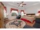 Cozy bedroom with a circular rug, tray ceilings, a ceiling fan, and comfortable furniture at 202 Westcott Ct, Deland, FL 32724