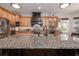 Spacious kitchen with stainless steel appliances, wood cabinets, granite countertops, and an island with a sink at 202 Westcott Ct, Deland, FL 32724