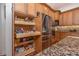 Kitchen with a stainless steel refrigerator, wood cabinets, granite countertop, and a large pull-out pantry for storage at 202 Westcott Ct, Deland, FL 32724