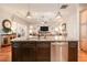 Open kitchen view showcasing a large island with a stainless steel dishwasher, hardwood floors, and an open view to the living room at 202 Westcott Ct, Deland, FL 32724