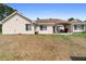 Expansive backyard showcasing the home's exterior with large windows and a covered patio area at 2048 Laredo Dr, Deltona, FL 32738