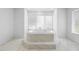 Bright bathroom featuring a luxurious soaking tub with tile surround and large window at 2048 Laredo Dr, Deltona, FL 32738