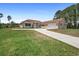 Single-story home with an attached garage and a well-manicured lawn extending to the concrete driveway at 2048 Laredo Dr, Deltona, FL 32738