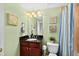 Bathroom with wood vanity and framed mirror and shower-tub with striped curtain at 2071 S Atlantic Ave # 705, Daytona Beach, FL 32118