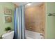Bathroom featuring a toilet, tub, and shower with tile walls and striped curtains at 2071 S Atlantic Ave # 705, Daytona Beach, FL 32118
