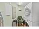 Functional laundry room with stacked washer/dryer, storage cabinets, and utility sink at 2071 S Atlantic Ave # 705, Daytona Beach, FL 32118