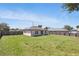 Spacious backyard with a well-maintained lawn, fenced perimeter, and solar panels on the roof at 223 Courtland Blvd, Deltona, FL 32738