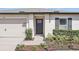 Inviting entryway with a dark front door, manicured landscaping, and modern accents at 223 Courtland Blvd, Deltona, FL 32738