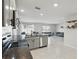 Modern kitchen featuring stainless steel appliances and dark granite countertops open to a living area at 223 Courtland Blvd, Deltona, FL 32738