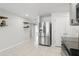 Open kitchen with stainless steel fridge, granite counters, and stylish floating shelves at 223 Courtland Blvd, Deltona, FL 32738