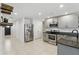 A modern kitchen features grey cabinetry, stainless steel appliances, granite countertops and stylish shelving at 223 Courtland Blvd, Deltona, FL 32738