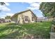 Large grassy backyard featuring a partial view of home, wooden fence, and mature trees at 227 Heronwood Cir, Deltona, FL 32725