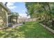 Secluded backyard with green grass, a patio set, mature trees, and a wooden fence at 227 Heronwood Cir, Deltona, FL 32725