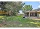 Spacious backyard showcasing healthy green grass, patio area, screened-in porch, and wooden fence at 227 Heronwood Cir, Deltona, FL 32725