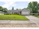 Charming one story home featuring a manicured lawn, neutral paint, and an attached two-car garage at 227 Heronwood Cir, Deltona, FL 32725