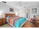 Inviting bedroom with hardwood floors, a ceiling fan and a colorful comforter at 227 Heronwood Cir, Deltona, FL 32725
