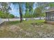 A lush backyard with a pristine lawn and a pool surrounded by a white fence and mature trees at 2355 W Orange Rd, Deland, FL 32724