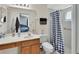 Bright bathroom with a shower featuring a black and white patterned curtain, alongside vanity at 2355 W Orange Rd, Deland, FL 32724