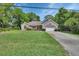 A one-story brick home features a well-manicured lawn and an attached two-car garage at 2355 W Orange Rd, Deland, FL 32724