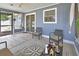 A sunroom with wicker furniture and a compass rug leads to the backyard through sliding glass doors at 2355 W Orange Rd, Deland, FL 32724