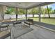 A sunroom with wicker furniture and a compass rug provides a relaxing view of the fenced-in backyard at 2355 W Orange Rd, Deland, FL 32724