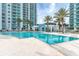 Stunning view of the refreshing outdoor swimming pool surrounded by palm trees and a modern high-rise at 241 Riverside Dr # 2110, Daytona Beach, FL 32117