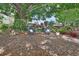 A backyard oasis featuring mature trees, lush landscaping, and comfortable seating for outdoor relaxation at 2427 Beck Cir, Deltona, FL 32738