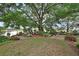 Expansive backyard featuring a serene pond, lush landscaping, and a charming seating area under the shade of a mature tree at 2427 Beck Cir, Deltona, FL 32738