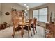 Bright dining room with a wood table set, display cabinet and natural light from large window at 2427 Beck Cir, Deltona, FL 32738