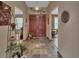 Inviting foyer with red double doors, tile flooring, plants, and decorative accents at 2427 Beck Cir, Deltona, FL 32738