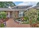 Close up of front entrance adorned with brick walkway, trellis, and lush landscaping at 2427 Beck Cir, Deltona, FL 32738