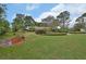 Expansive front yard with mature trees and meticulous landscaping surrounds this suburban home at 2427 Beck Cir, Deltona, FL 32738