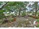 Landscaped gardens with stone patio, fire pit, seating, plants, and a big tree at 2427 Beck Cir, Deltona, FL 32738
