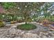 Lush garden with a stone path, chairs, plants, flowers, and a big tree at 2427 Beck Cir, Deltona, FL 32738