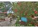 Gardens with many plants and flowers with a walkway and a sign that says, 
